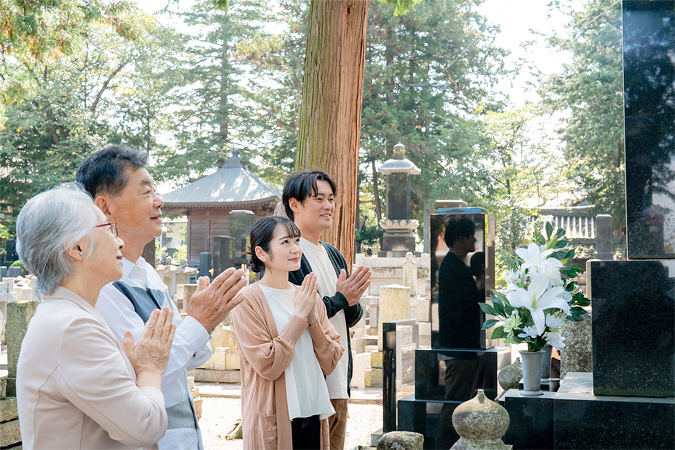 お墓参りをする家族のイメージ